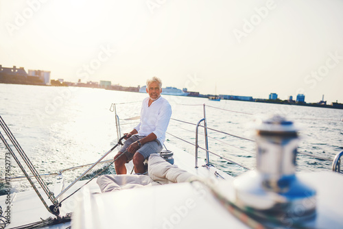 Mature man sailing his boat alone on the ocean