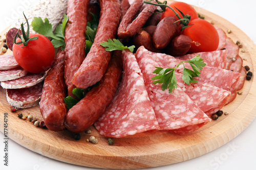 Food tray with delicious salami, pieces of sliced ham, sausage, tomatoes, salad and vegetable - Meat platter with selection - Cutting sausage and cured meat