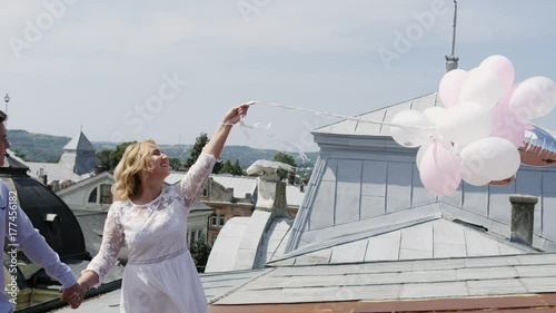 Couple holding some ballons on the rooftoop. photo