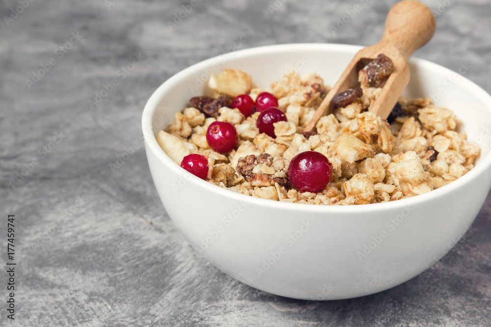Granola muesli and cranberry berries for breakfast natural on a gray marble background with copy space, concept of a healthy diet Granola muesli and cranberry berries for breakfast natural on a gray marble background with copy space, concept of a healthy diet