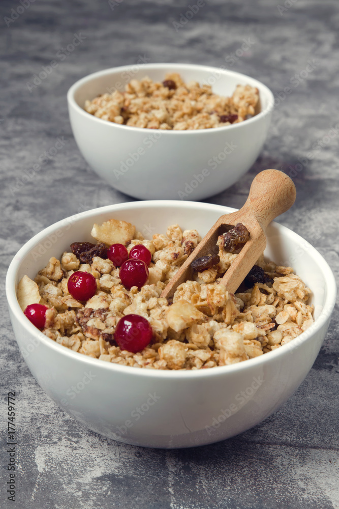 Granola muesli and cranberry berries for breakfast natural on a gray marble background with copy space, concept of a healthy diet Granola muesli and cranberry berries for breakfast natural on a gray marble background with copy space, concept of a healthy diet
