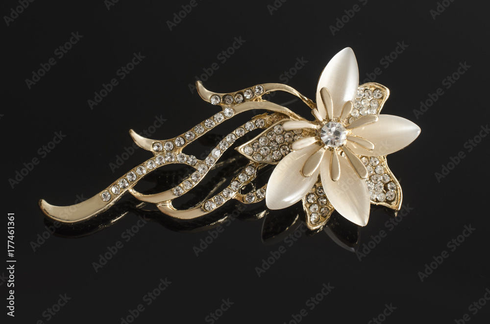 Fototapeta premium gold brooch flower with gems and moon stone isolated on black
