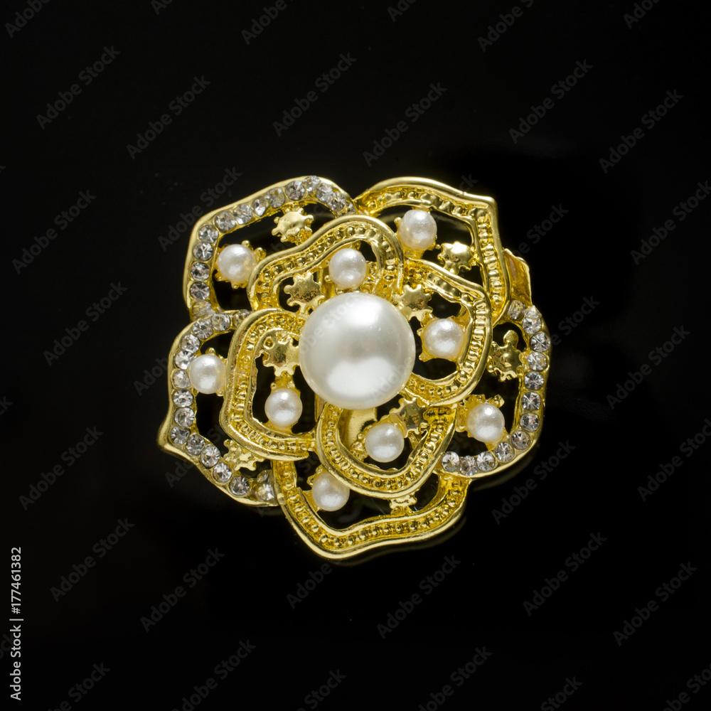 gold brooch flower with pearl isolated on black gold brooch flower with pearl isolated on black