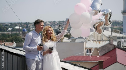 Couple holding some ballons and coffee on the rooftoop. photo