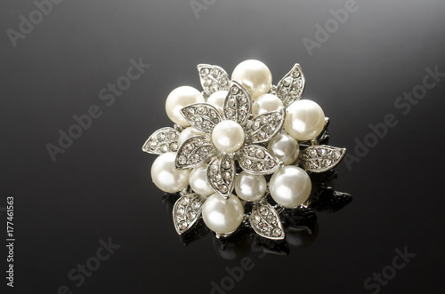 silver brooch flower with pearl isolated on black