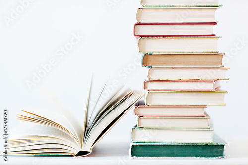 An open book next to a stack of books photo