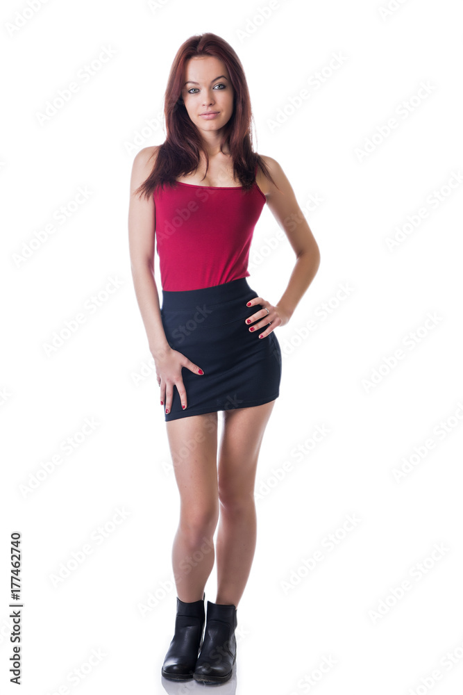 Young beautiful red haired woman standing, in studio shot, looking at camera Young beautiful red haired woman standing, in studio shot, looking at camera