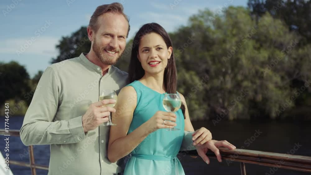 Couple on romantic vacation drinking wine on boat trip & looking at the view Couple on romantic vacation drinking wine on boat trip & looking at the view