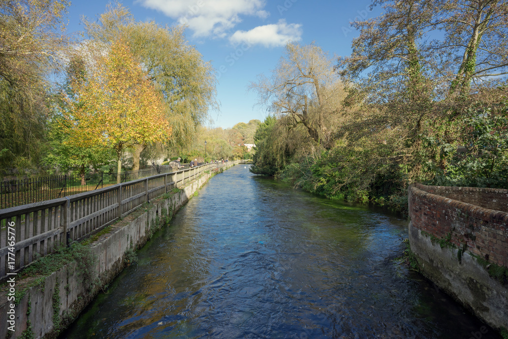 The River Itchen weirs gardens in Winchester on a sunny Autumn day