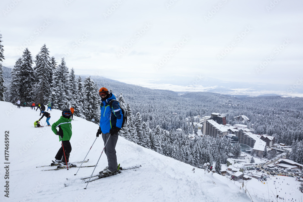 Alpine ski resort Borovets, Rila mountain, Bulgaria. Ski slope, people skiing down the hill, mountains view