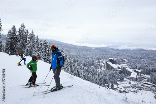 Alpine ski resort Borovets, Rila mountain, Bulgaria. Ski slope, people skiing down the hill, mountains view