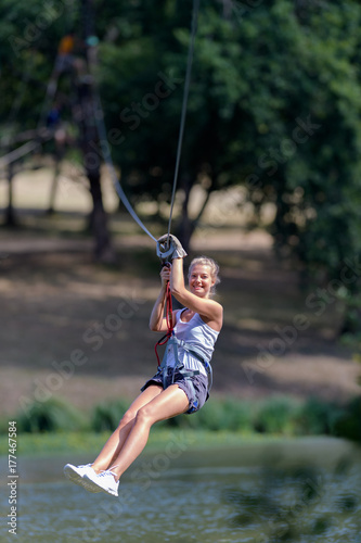 young woman climbing in a rope playground structure