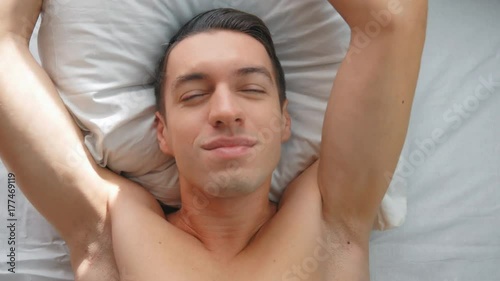 Young man wakes up and yawns in the morning