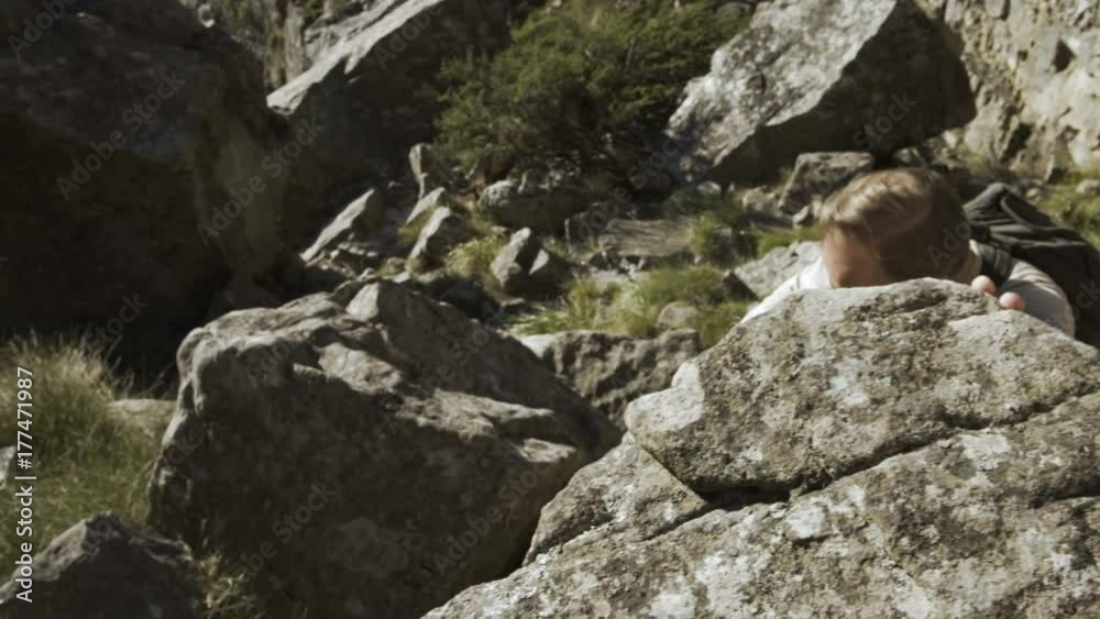 Fit & active man climbing mountain range & looking out at the view Fit & active man climbing mountain range & looking out at the view