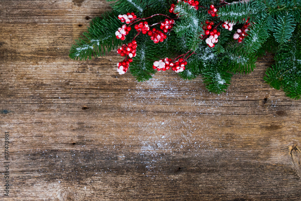 twig with red berries and green evergreen tree on aged wooden background with copy space twig with red berries and green evergreen tree on aged wooden background with copy space