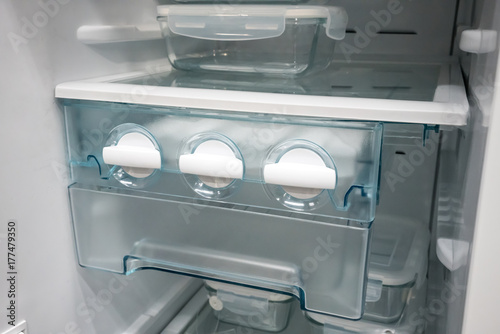 Closed up white side by side ice maker and ice tray