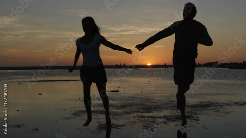 Wallpaper Mural  Romantic couple holding hands, running on beautiful sandy beach at sunset Torontodigital.ca