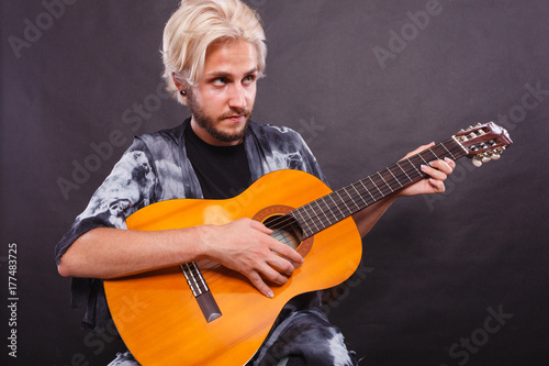 Blonde man playing acoustic guitar photo