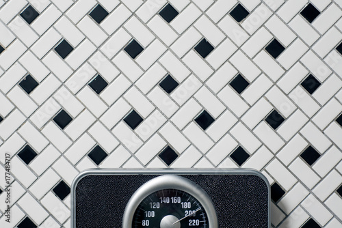 A bathroom scale found on a tiled floor