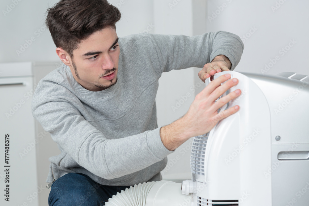 Man working on air conditioning unit Man working on air conditioning unit