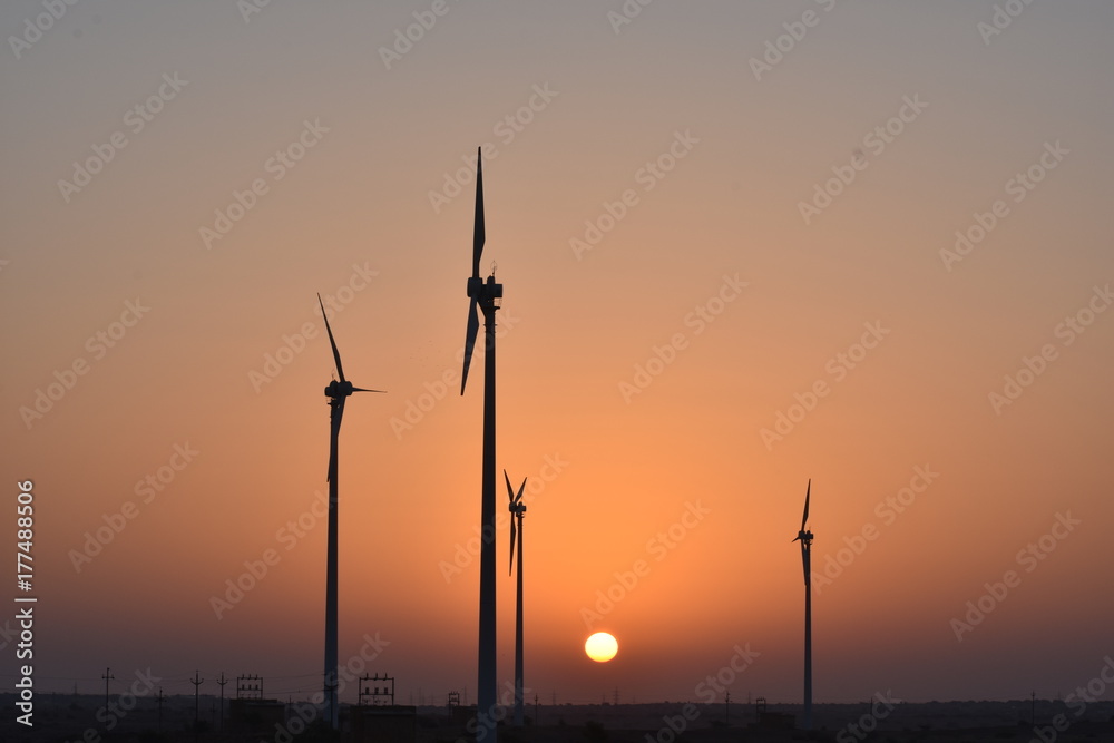Obraz premium sunrise with modern windmills in thar desert india