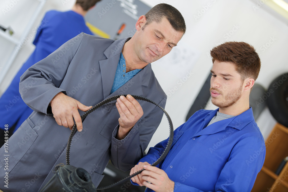 Obraz premium Mechanics inspecting rubber belt