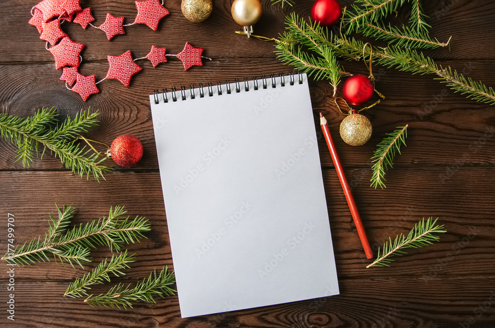 Empty white page of spiral notebook and christmas decoration on a wooden background. Flat lay. Empty white page of spiral notebook and christmas decoration on a wooden background. Flat lay.