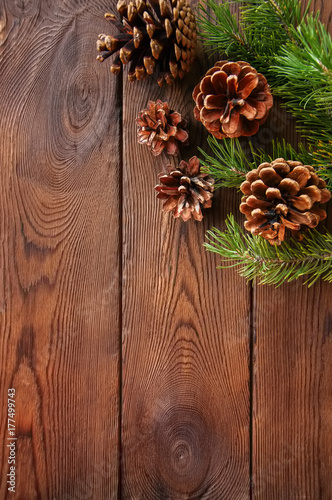 Christmas background. Fir tree branches and cones on a wooden backdrop. Copy space. Top view.