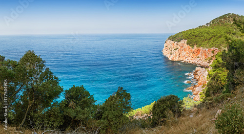 Idyllic Mediterranean landscape with a solitary bay of azure color and mountains covered with pine forest, travel in paradise concept © EdNurg