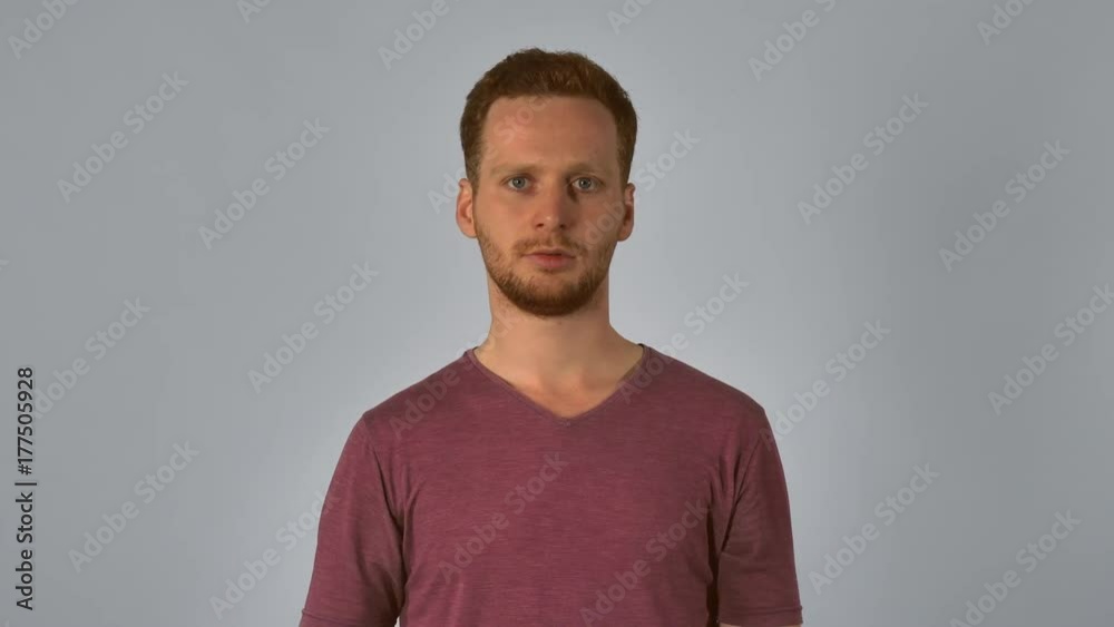 Portrait young caucasian man on grey background. caucasian guy with red hair posing showing hand gesture stop. handsome redhead men wearing in casual t-shirt