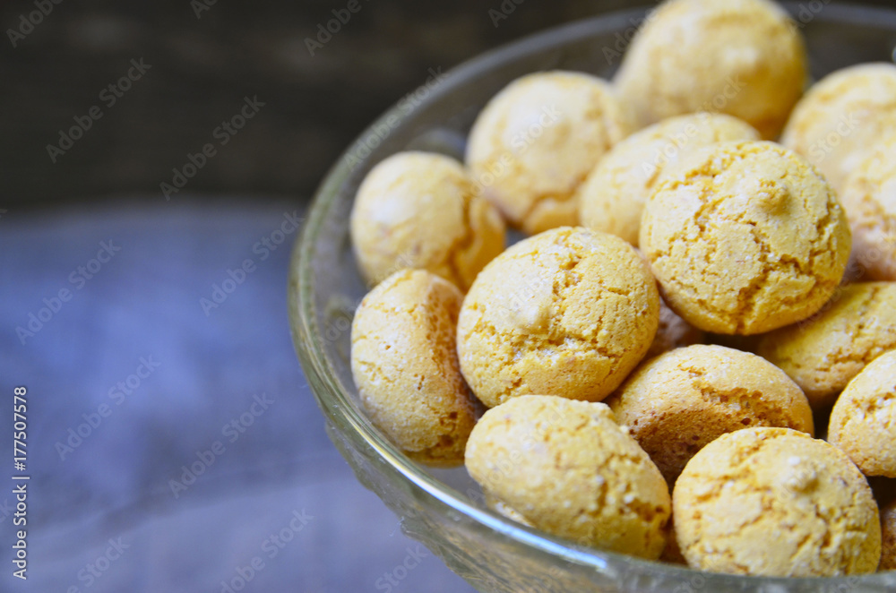 Amaretti cookies in a glass bowl on old wooden background.Italian amarettini biscuits.Amarettini cookies.Tasty Italian amaretti biscuits.Selective focus.