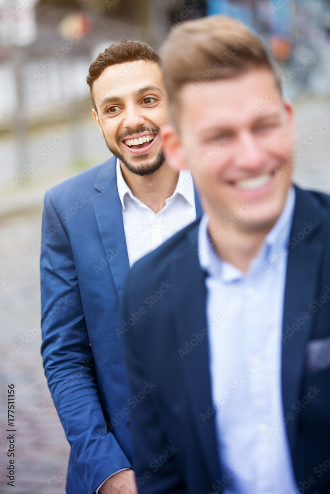 two businessmen standing outside and laughing two businessmen standing outside and laughing