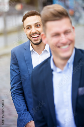 two businessmen standing outside and laughing