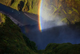 Rainbow on the background of rocks, foot of Skogafoss waterfall, Iceland