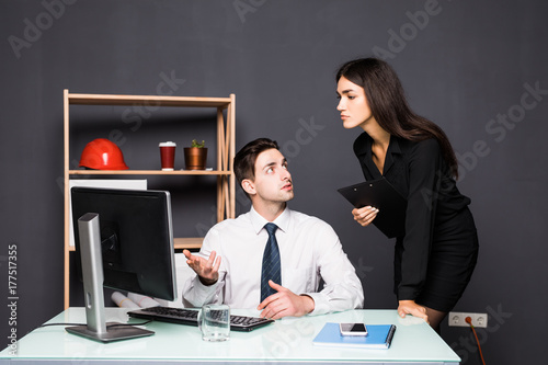 Attractive photo editor pointing at the screen while working with a colleague at office photo