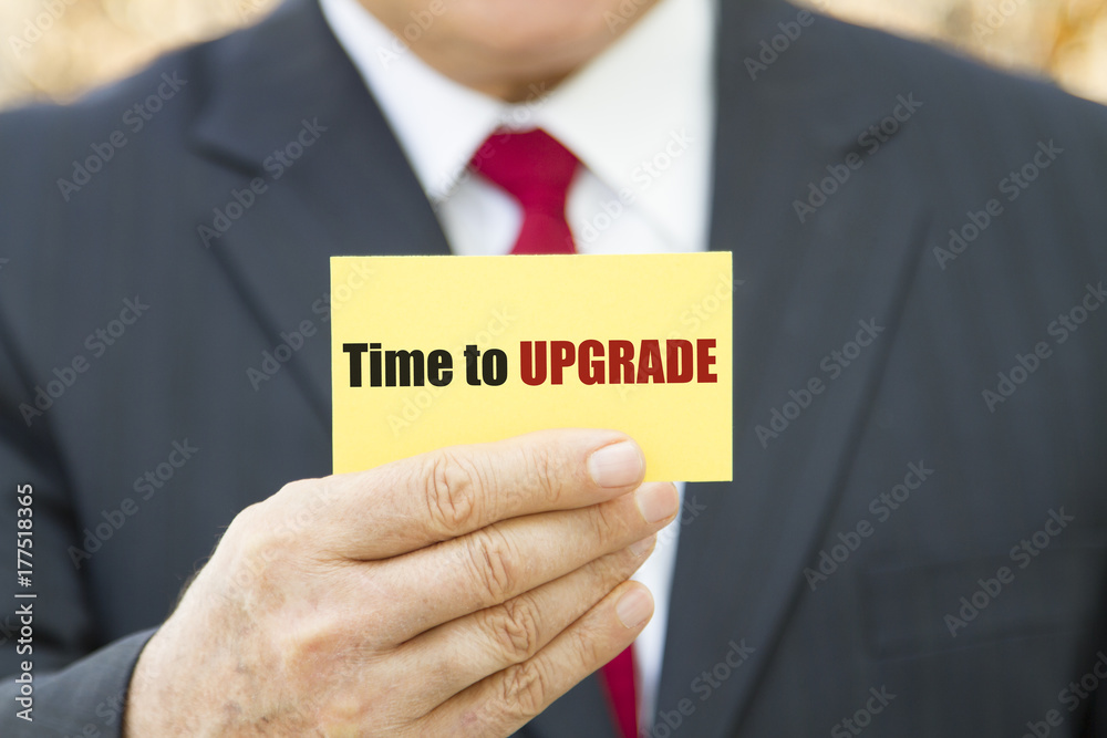Obraz premium Businessman showing a card with text TIME TO UPGRADE