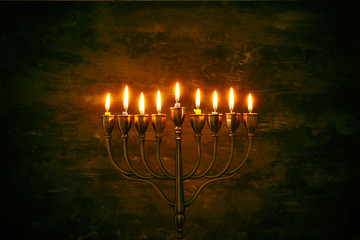 Low key image of jewish holiday Hanukkah background with menorah (traditional candelabra) and burning candles