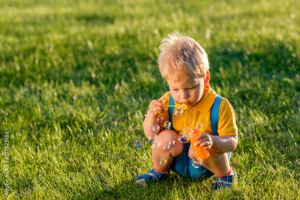One year old baby boy blowing soap bubbles One year old baby boy blowing soap bubbles
