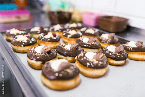 Chocolate glazed decorated donuts ready for sale in a small town bakery. 