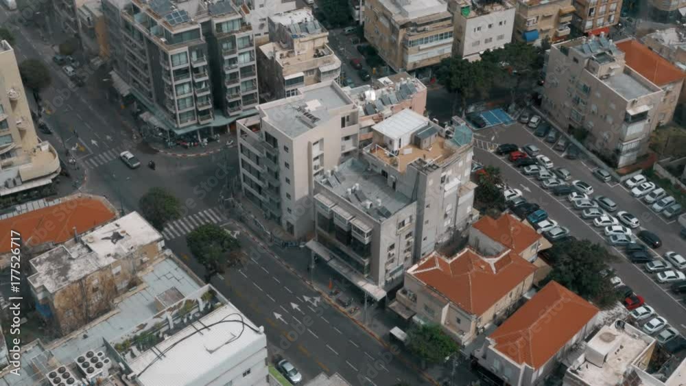 High angle shot of city street in Tel Aviv. View to the car traffic on crossroad, houses and parking lot High angle shot of city street in Tel Aviv. View to the car traffic on crossroad, houses and parking lot
