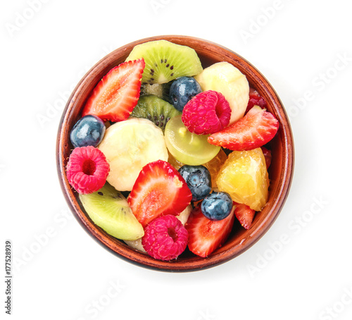 Bowl with delicious fruit salad on white background