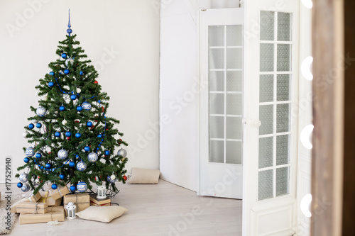 Christmas tree with blue in a white room with toys for Christmas