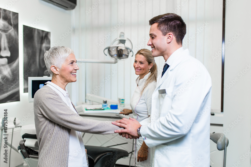 Beautiful senior woman at dentist office going home after successful dental treatment. Beautiful senior woman at dentist office going home after successful dental treatment.