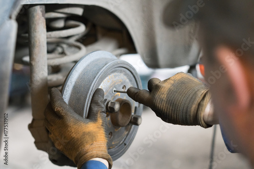 Close-up repair drum brake of car wheel in garage. photo