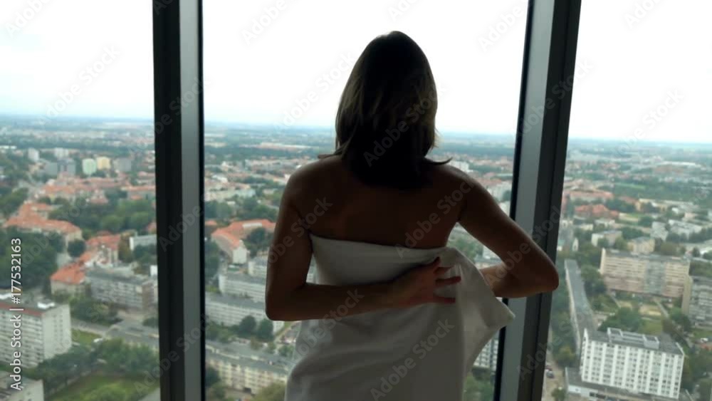 Woman putting on towel by window at home and admire view, super slow motion 240fps
Woman putting on towel by window at home and admire view, super slow motion 240fps
