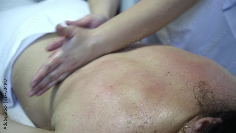 Therapeutic massage medical. An experienced masseur woman does a therapeutic massage to a thick patient with black hair. Massage is performed on the back, legs, neck, feet, hands. Therapeutic massage medical. An experienced masseur woman does a therapeutic massage to a thick patient with black hair. Massage is performed on the back, legs, neck, feet, hands.