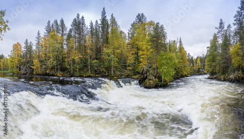 Cliff, stone wall, forest, waterfall and wild river panoramic view in autumn. Fall colors - ruska time in Myllykoski. Karhunkierros Trail, Oulanka National Park in north Finland. Lapland, Europe