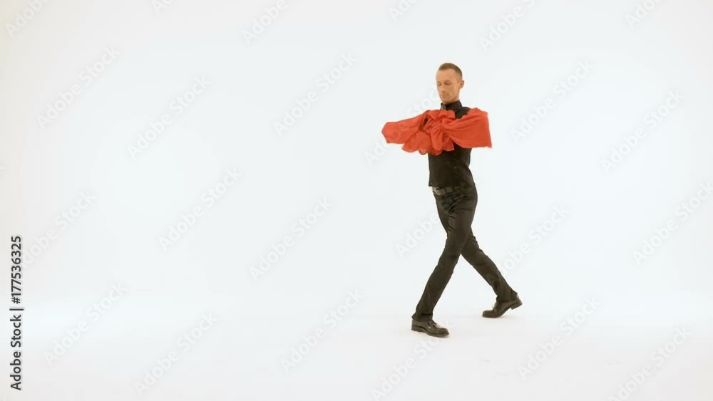 A young man in a black suit is dancing on a white background. A young man in a black suit is dancing on a white background.