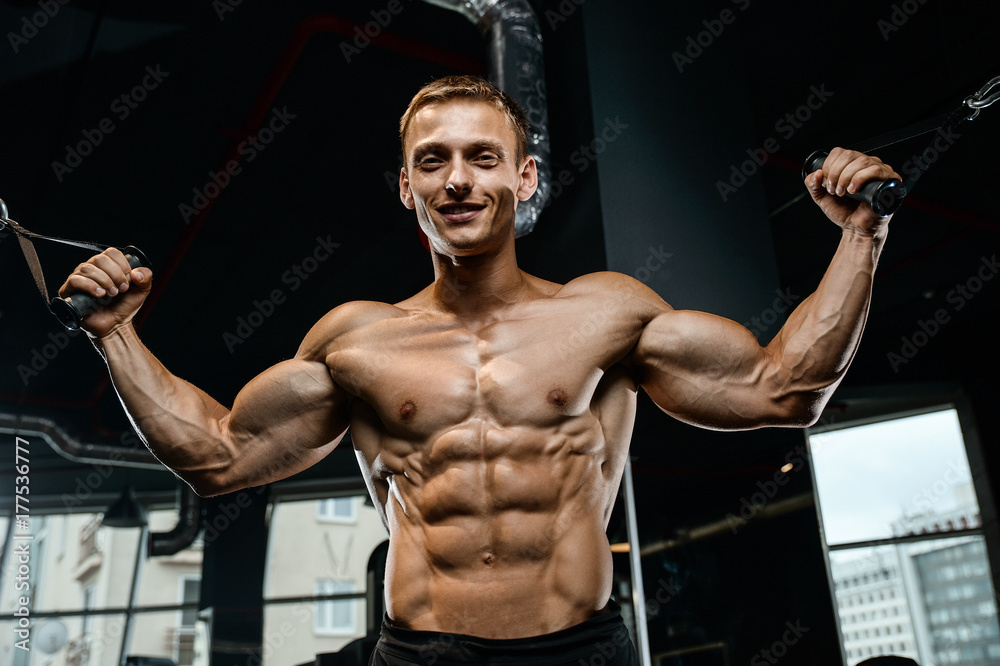 Obraz premium Handsome model young man training arms in gym
