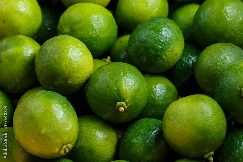 Closeup of many green juicy lime fruits in basket Closeup of many green juicy lime fruits in basket
